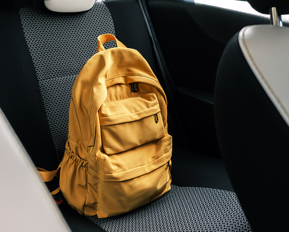 žltý batoh uložený na zadnom sedadle auta 