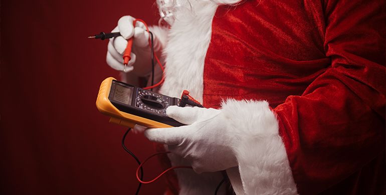 muž oblečený ako Santa Claus drží elektronické zariadenie 