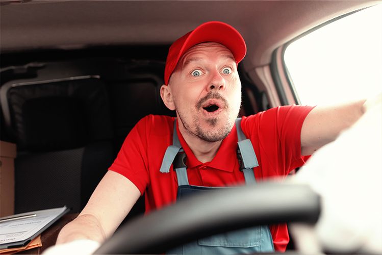 muž v červenej košeli a červenom klobúku v aute 