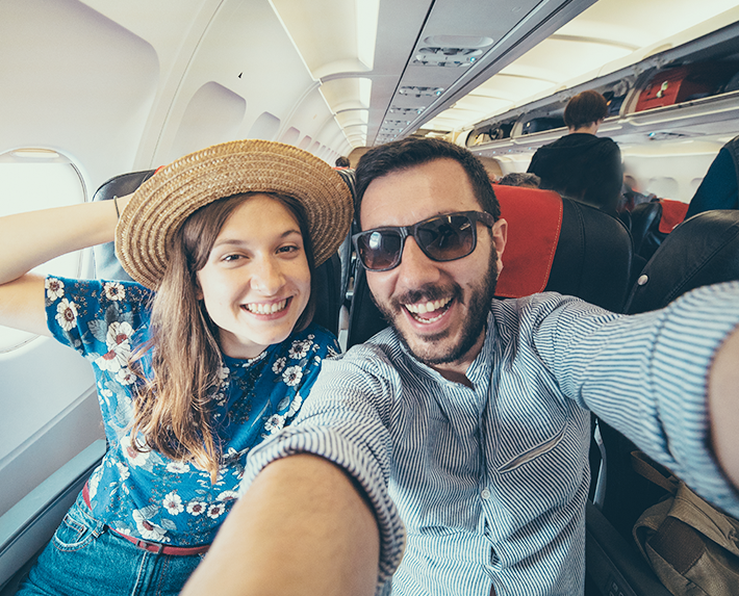 muž a žena, ktorí si robia selfie v lietadle 